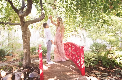 mother and son dancing in a garden together