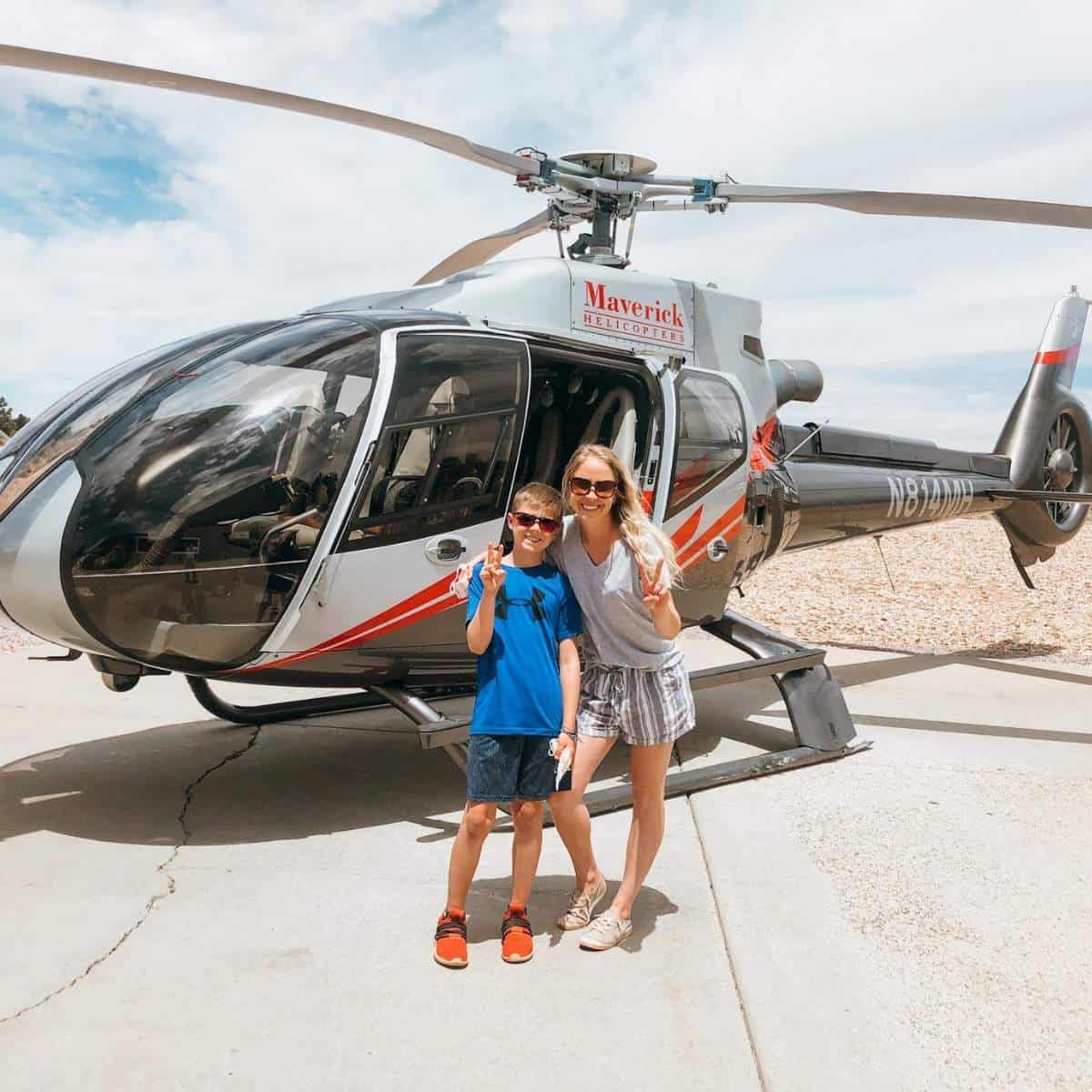 mom and son standing in front of helicopter