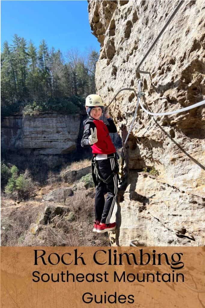 Boy on side of climb rock climbing in a red and black outfit