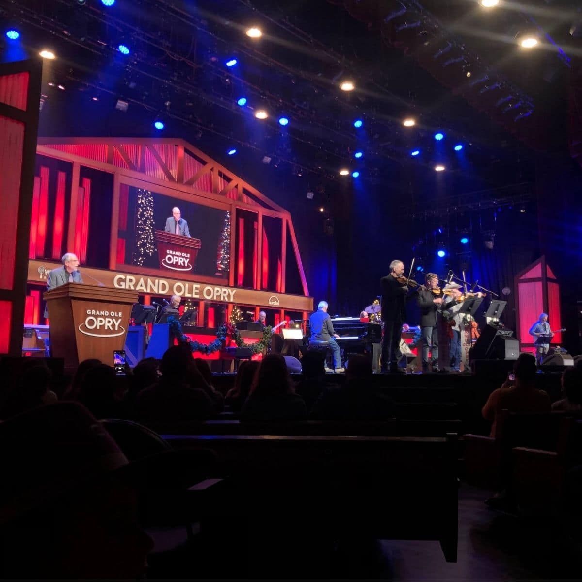 grand ole Opry stage with performers playing the piano and violin