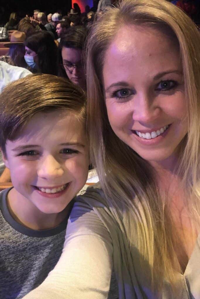 Mother and son smiling together inside the Grand Ole Opry House, capturing a memorable visit. 