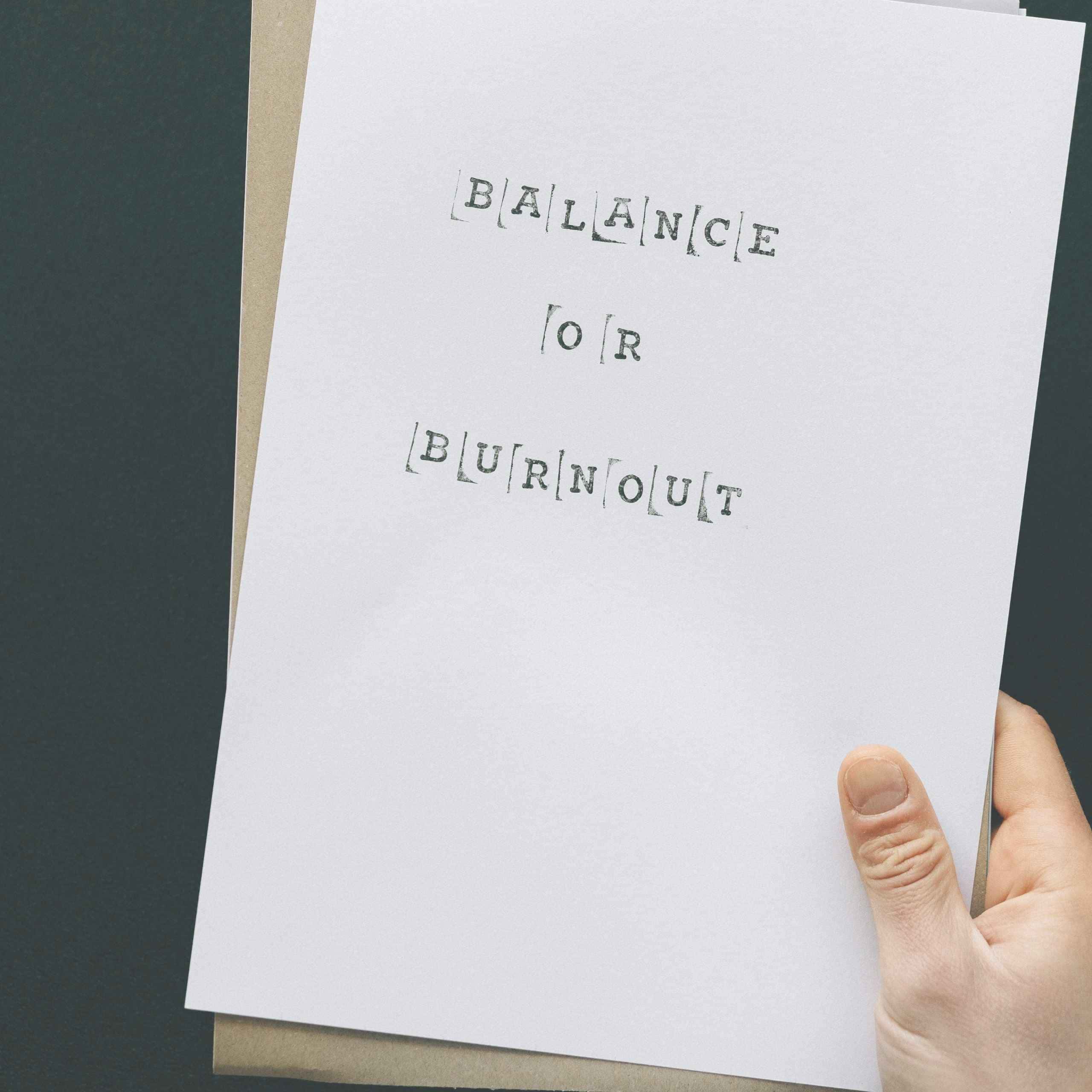 Hand holding paper reading "Balance or Burnout," symbolizing intentional living, boundaries, and choosing peace. 